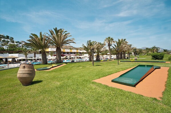 A pool area with a green pool table, palm trees, and a large decorative pot. - Lagas Aegean Village (Kos Town)