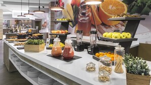 Een buffet met verschillende soorten eten, waaronder fruit, groenten en sauzen.