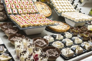 A variety of desserts displayed on trays and in bowls.