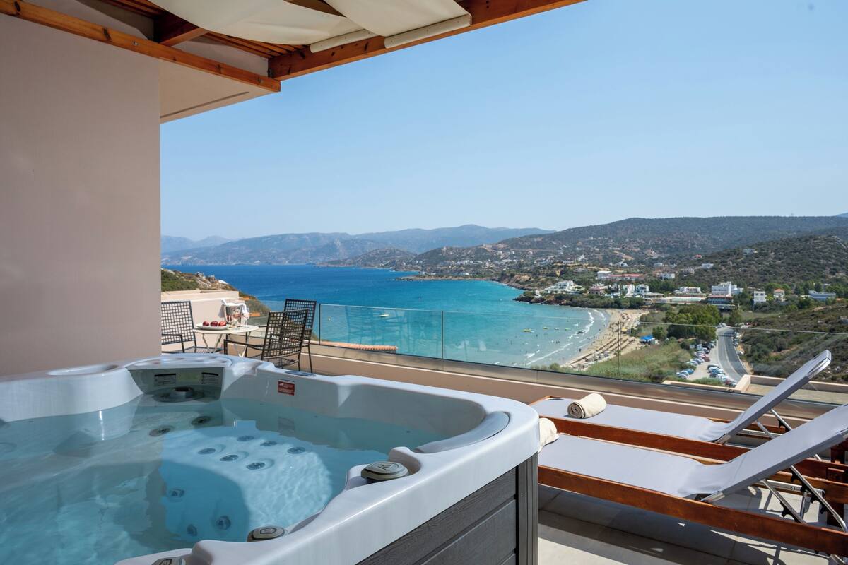 A hot tub with a clear view of the sea and a coastal town.