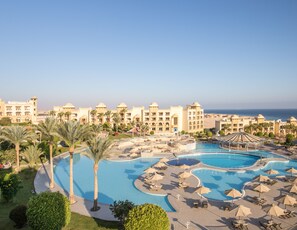 A resort with multiple swimming pools, palm trees, and a beach view. - SRNTY Sea Reef - Ex Serenity Alpha Beach (Makadi Bay)