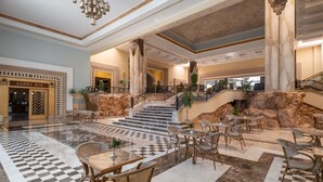 A lobby with a checkered floor, a staircase, and a lobby bar. - SRNTY Sea Reef - Ex Serenity Alpha Beach (Makadi Bay)