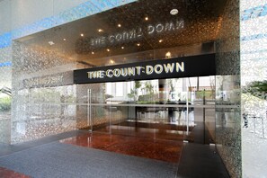 A modern hotel entrance with a glass facade and a sign reading "The Count: Down".