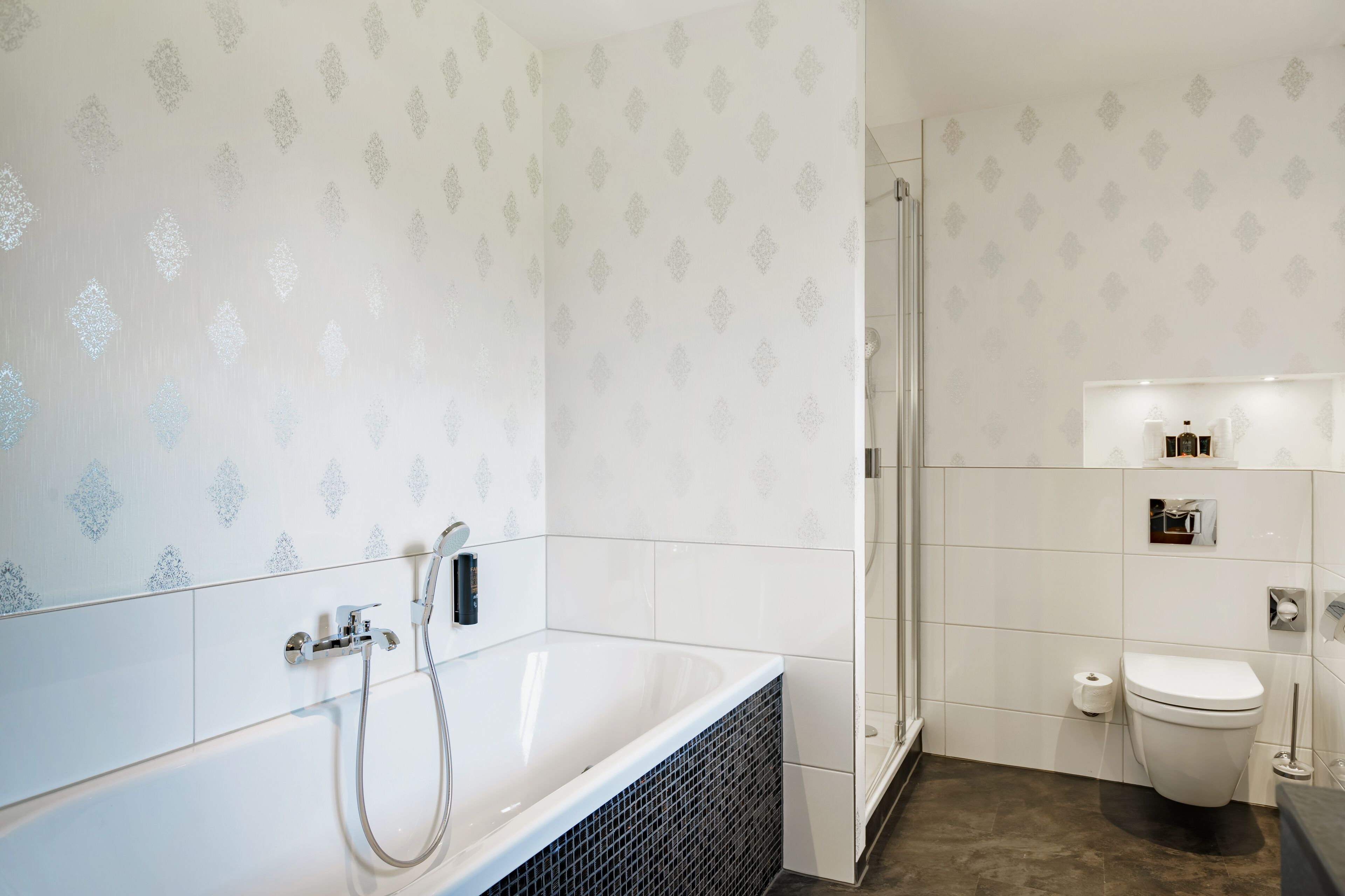 A modern bathroom with a freestanding bathtub, a glass shower enclosure, and a toilet.