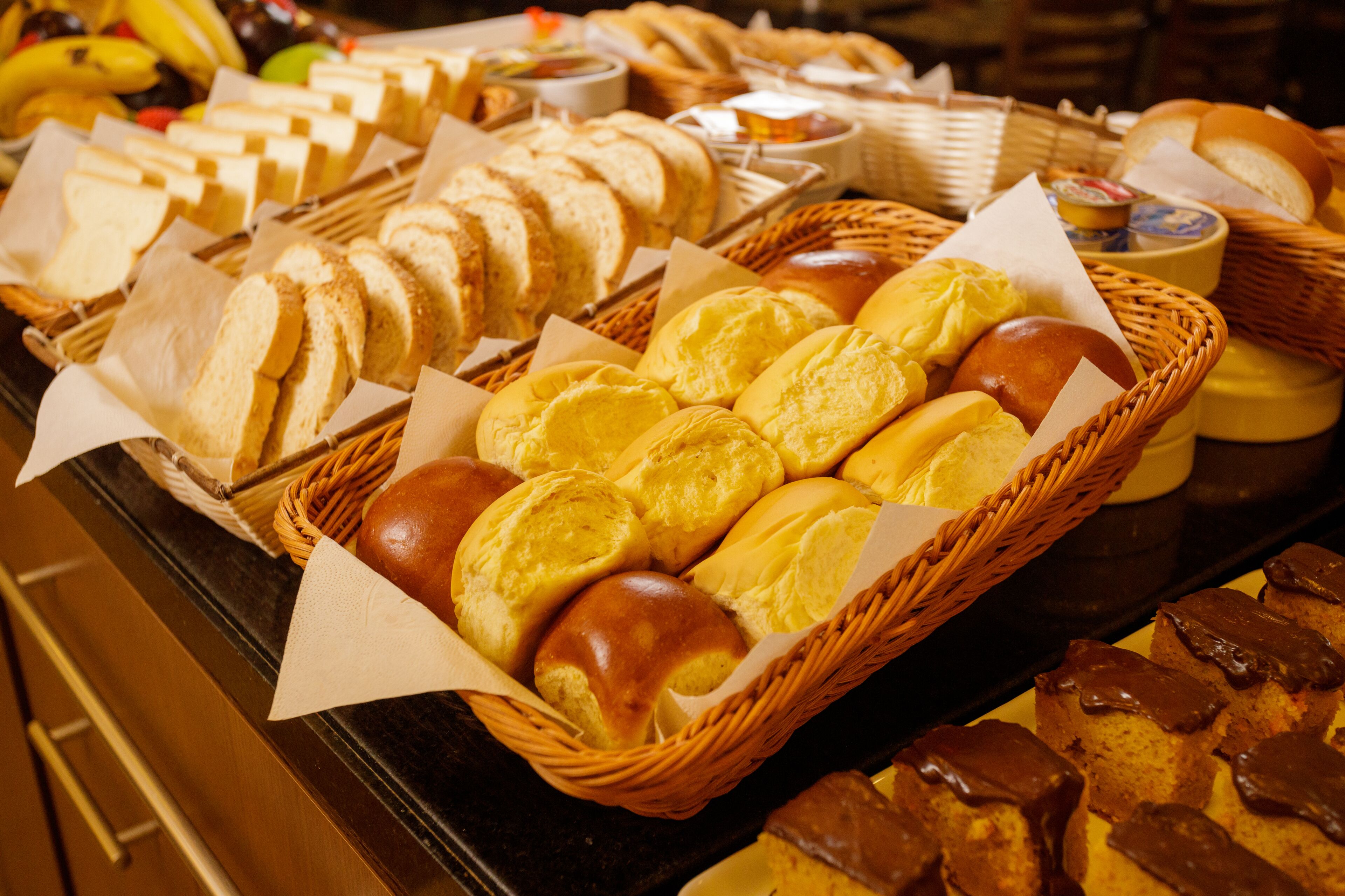 Un bufé con panes y pasteles variados.