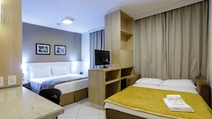 A hotel room with two beds, a desk, a TV, and a wardrobe. - Interclass Florianópolis (Florianópolis)