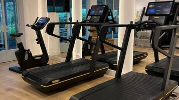 A gym with treadmills, stationary bikes, and a rowing machine.