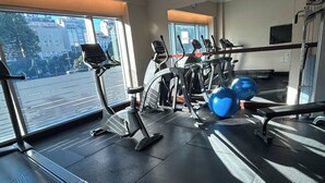 Un gimnasio con cintas de correr, elípticas y pelotas de ejercicio.