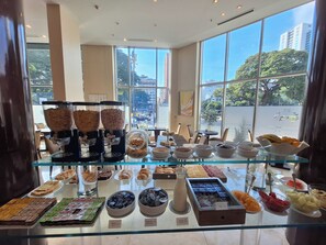 Un buffet de petit-déjeuner proposant une variété d’aliments et un coin café.