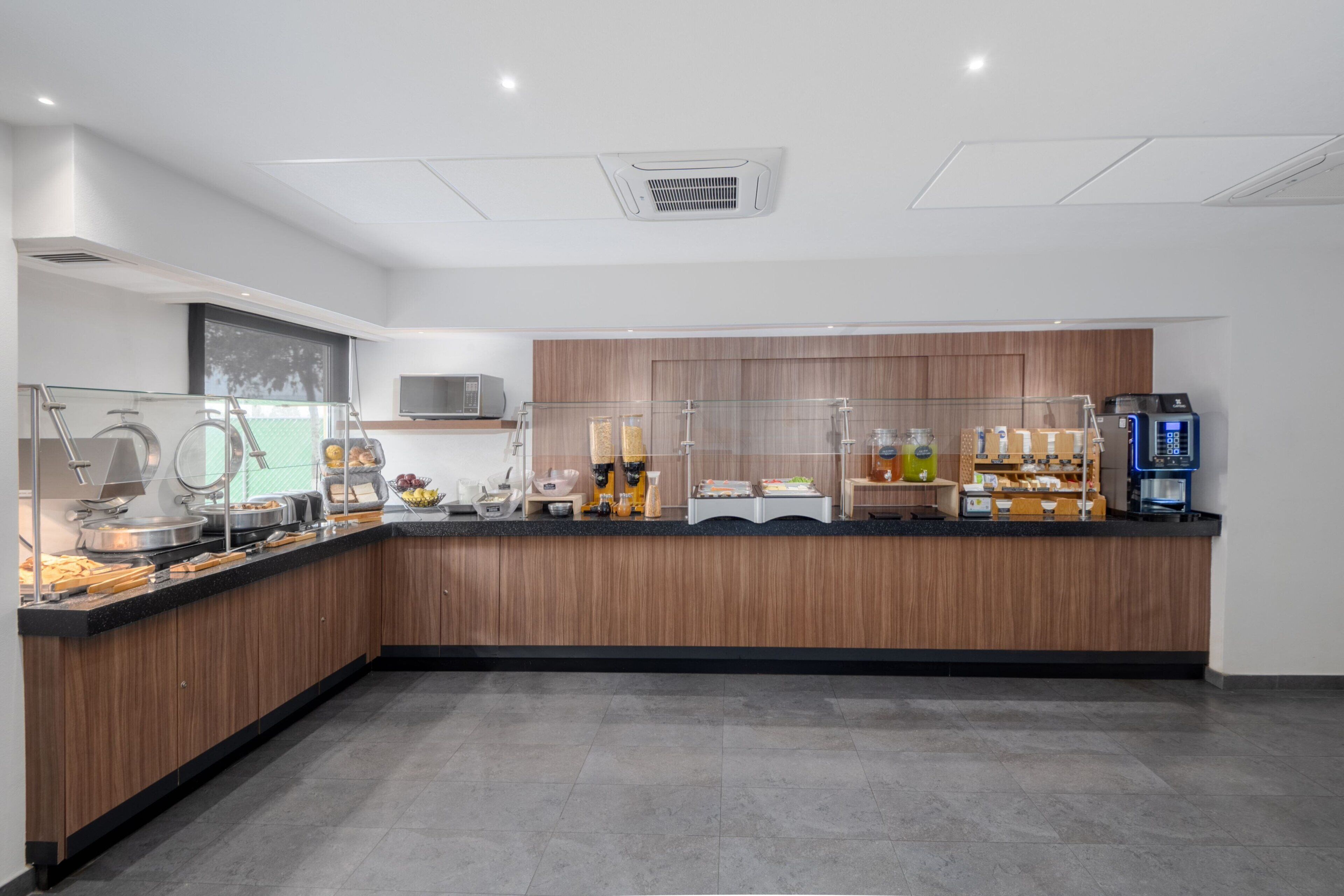 A modern breakfast bar with a variety of food items and a coffee machine.