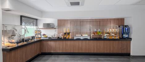 A modern breakfast bar with a variety of food items and a coffee machine.