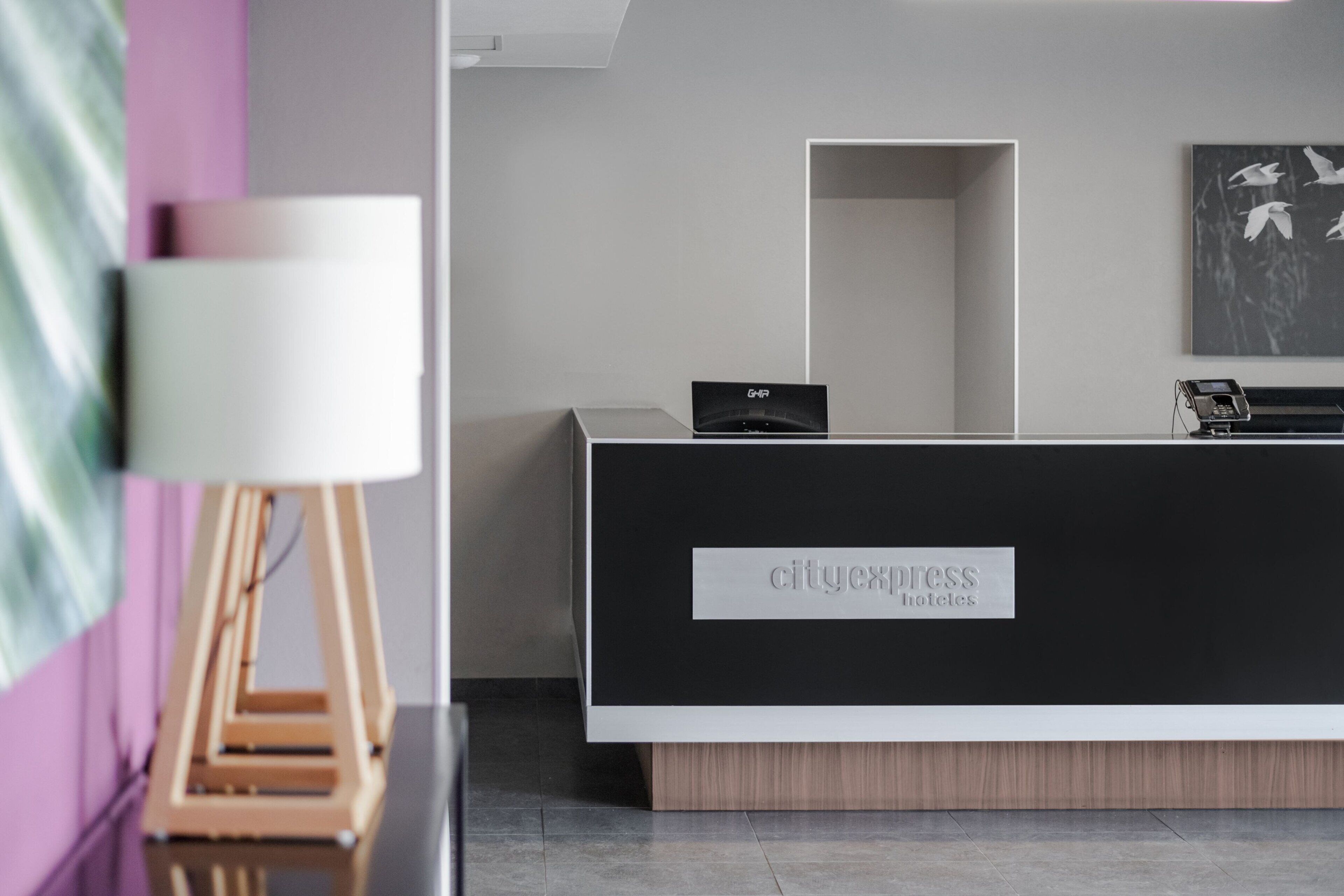 Un mostrador de recepción con un letrero que dice 'cityexpress hotels'.