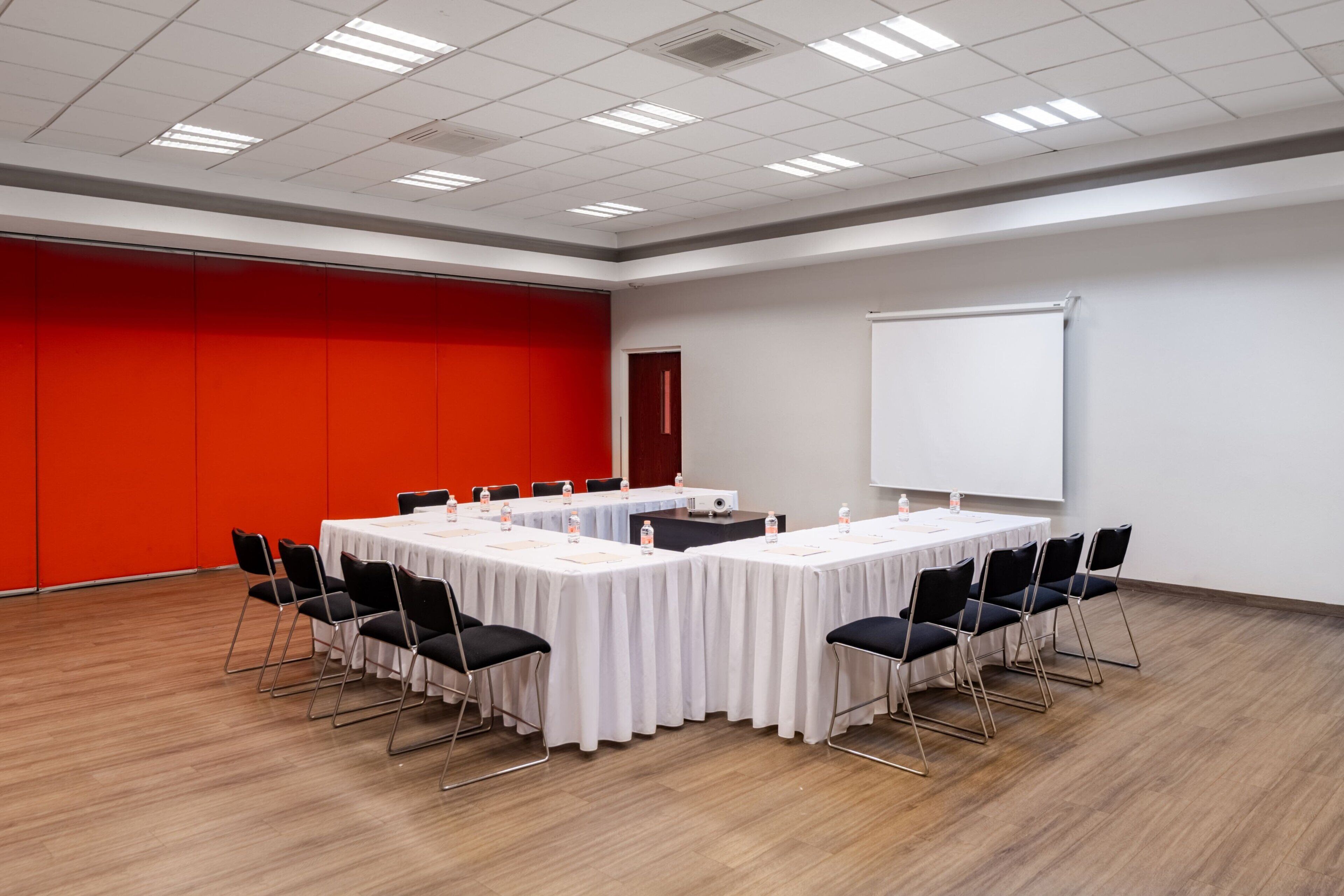 A conference room with a long table, black chairs, and a whiteboard.