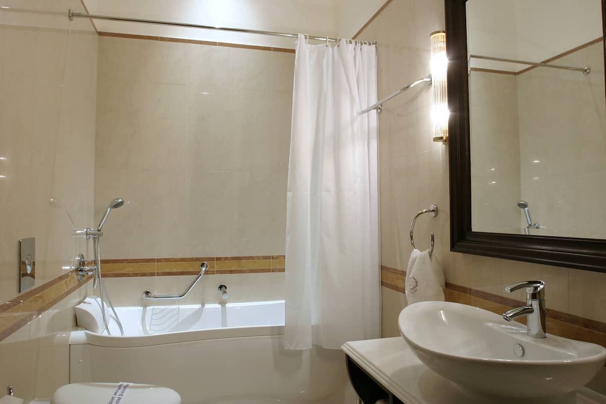 Ein modernes Badezimmer mit Badewanne, Dusche und Waschbecken.