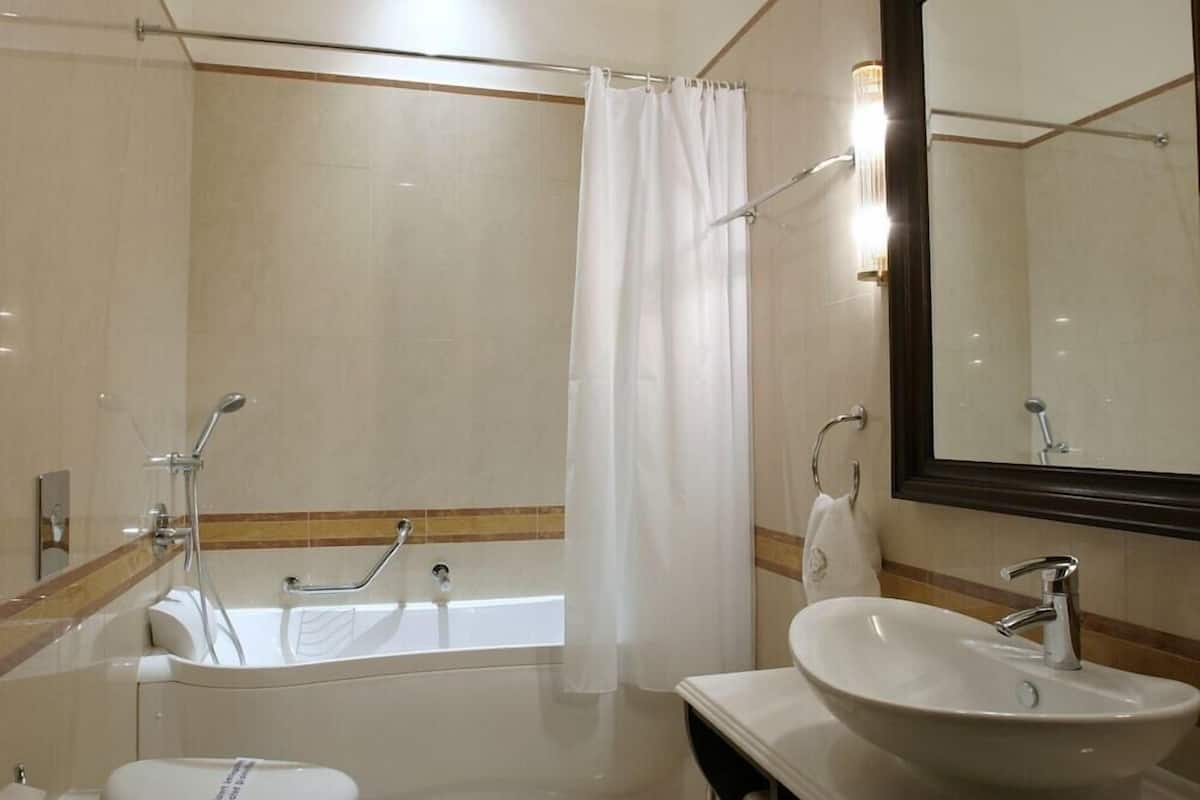 Ein Badezimmer mit Badewanne, Waschbecken, Dusche und Spiegel.