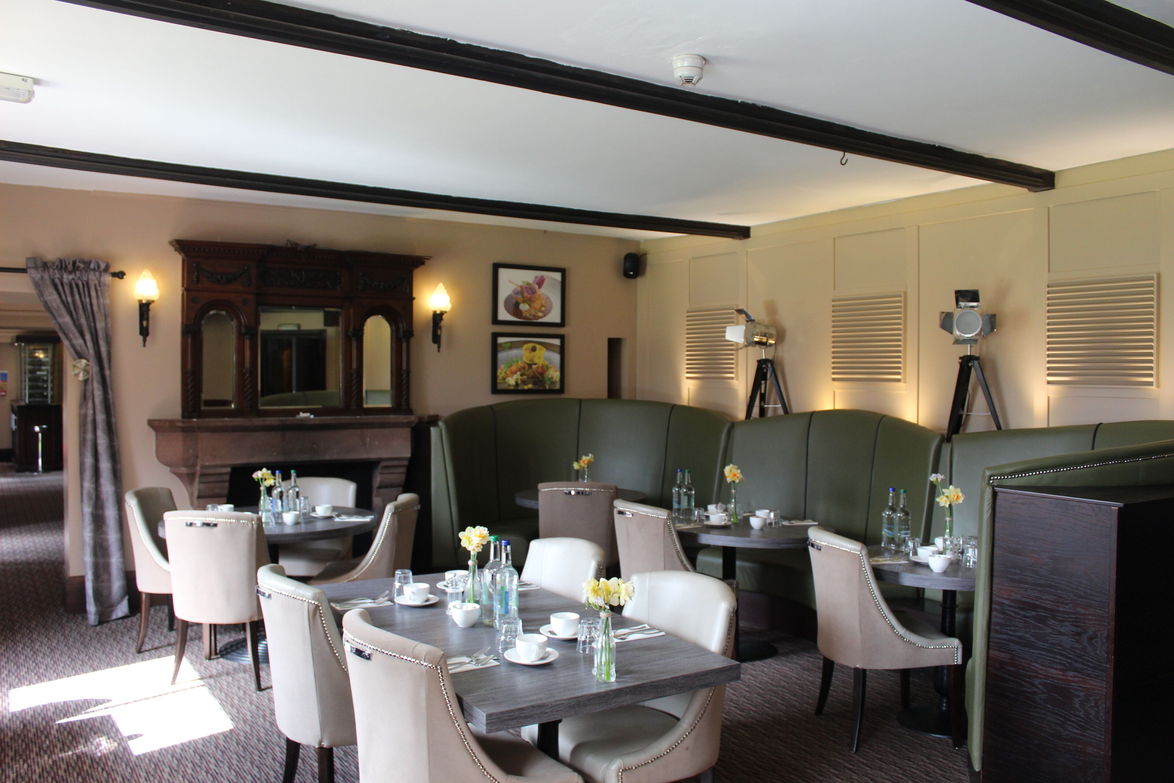 A restaurant with booth seating, a fireplace, and framed artwork on the walls.