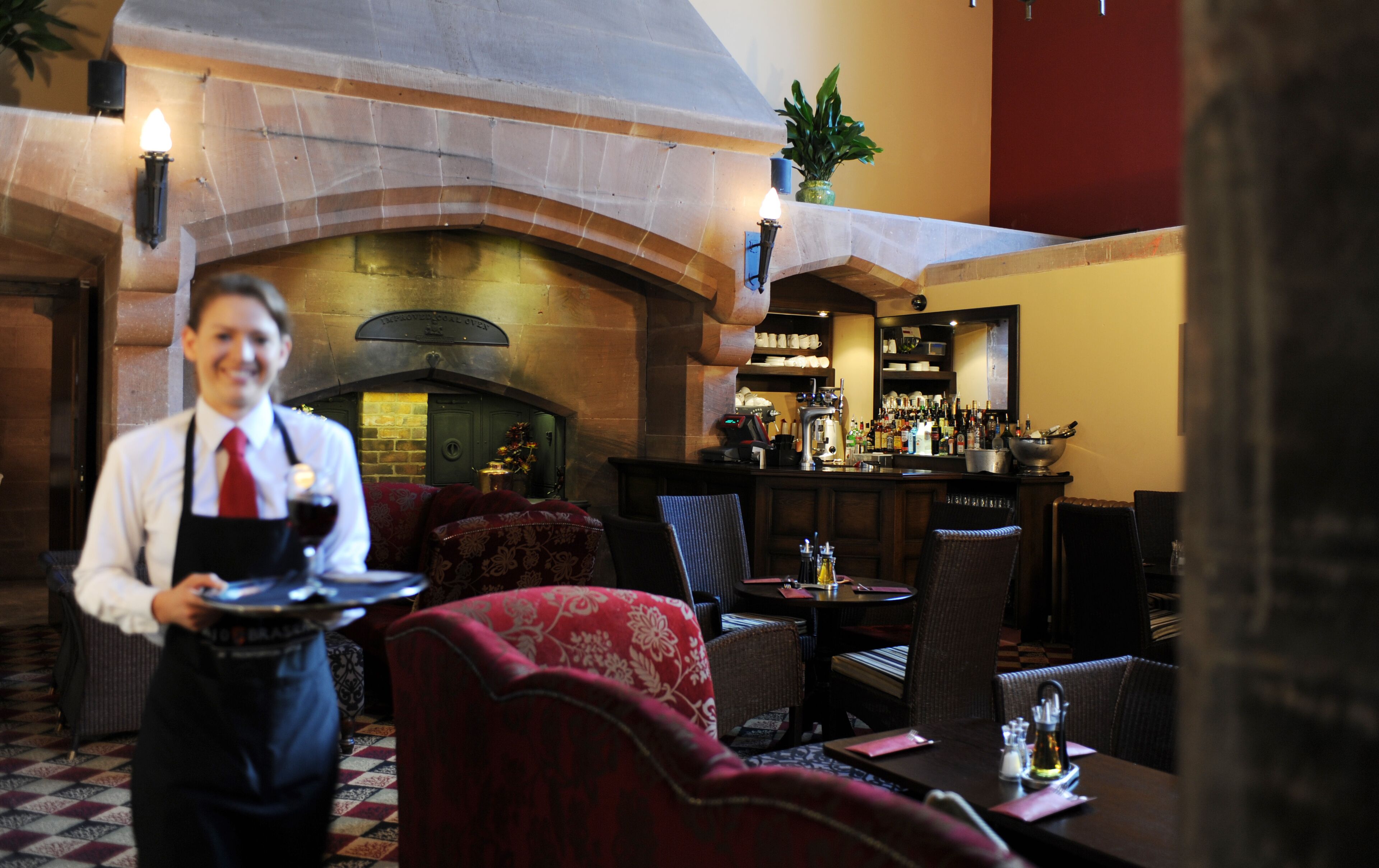 Ein Restaurant mit Kamin, Bar und Sitzgelegenheiten.