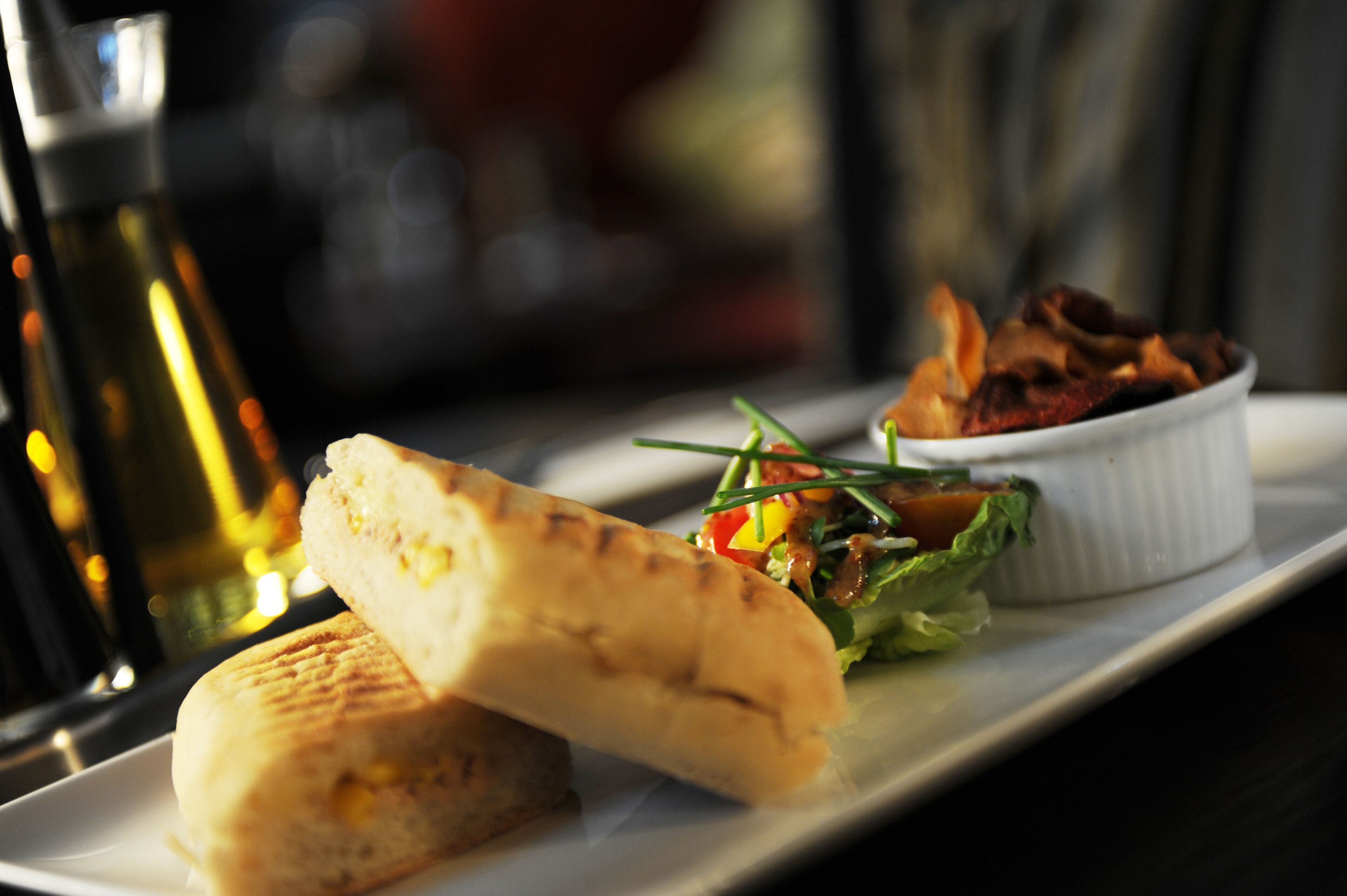 A sandwich and a small salad on a white plate.