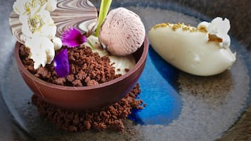 A dessert with ice cream and crumbled chocolate, served on a decorative plate.