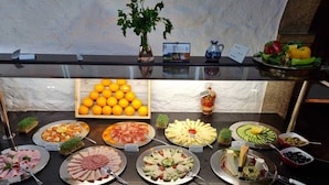 A buffet with various food items including fruits, cheeses, and meats. - Atlas Grand Hotel (Garmisch-Partenkirchen)
