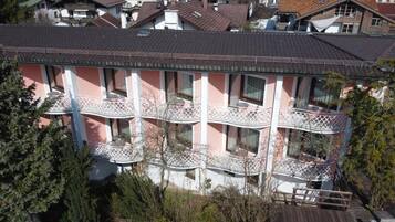 Un edificio de varios pisos con balcones y un espacio exterior cubierto.