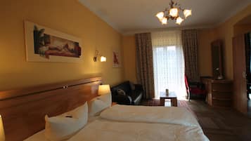 Ein Hotelzimmer mit einem großen Bett, einer Couch, einem Schreibtisch und einem Kronleuchter.