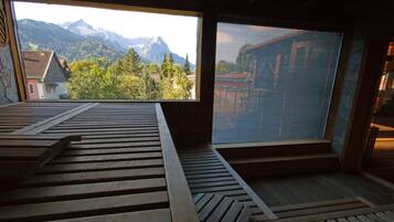 A room with a large window overlooking a mountain landscape.