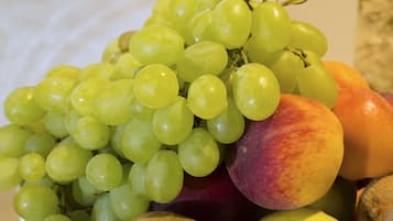 A bowl of fruit including grapes and peaches.