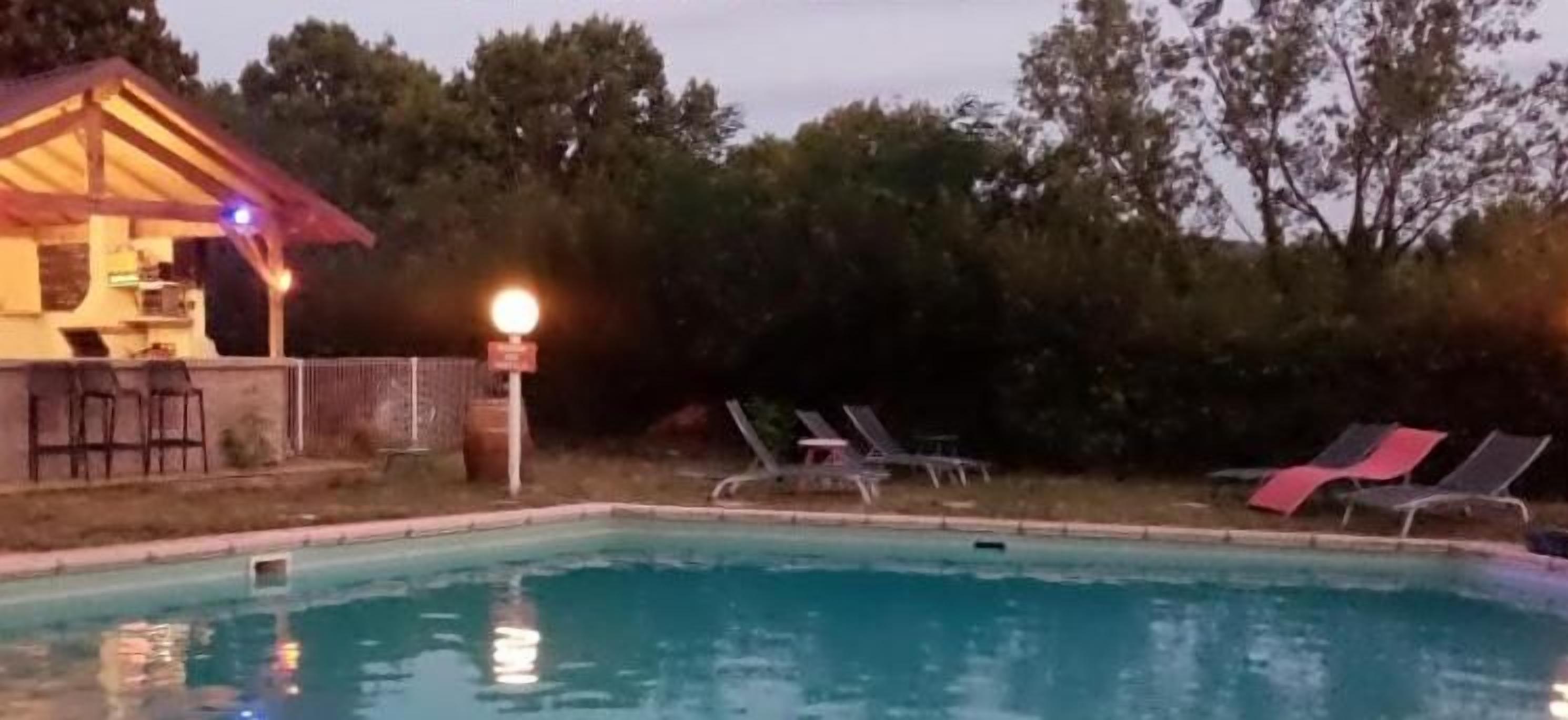 Una piscina con sillas de descanso y un edificio de techo rojo.