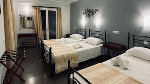 Une chambre d’hôtel avec deux lits, un bureau, une chaise et une fenêtre avec des rideaux.