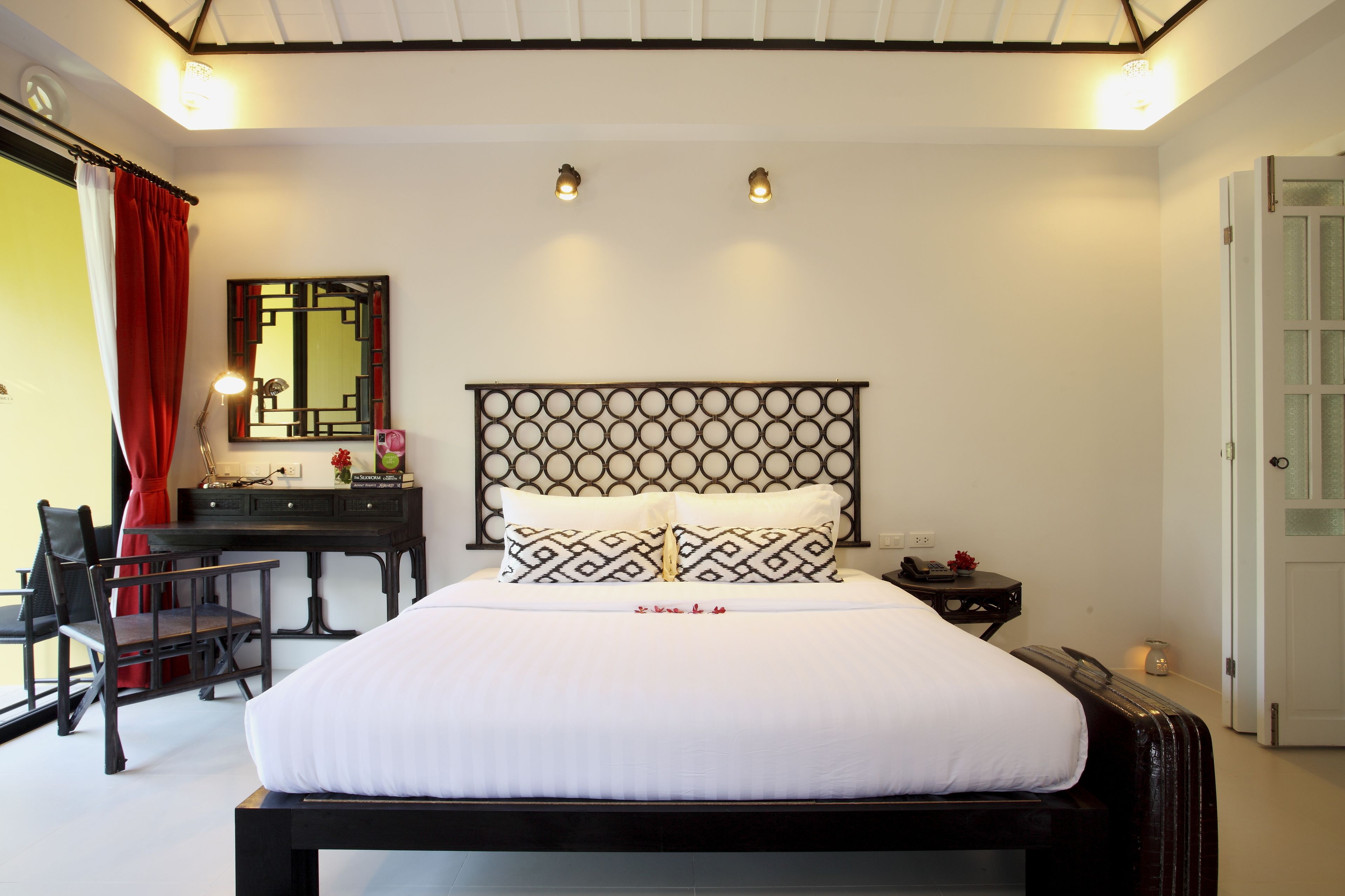 Un dormitorio ordenado con cama, escritorio y silla.