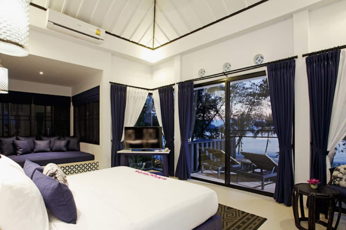 Une chambre d’hôtel moderne dotée d’un grand lit, d’un canapé, d’une télévision et d’un balcon offrant une vue sur l’extérieur.