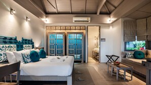 Hotelkamer met een bed, bureau, stoel, klein tafeltje, raam met uitzicht en een airconditioning.
