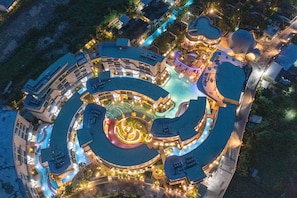An aerial view of a resort with a central pool, multiple buildings, and well-lit pathways. - Metadee Concept Hotel (Karon)