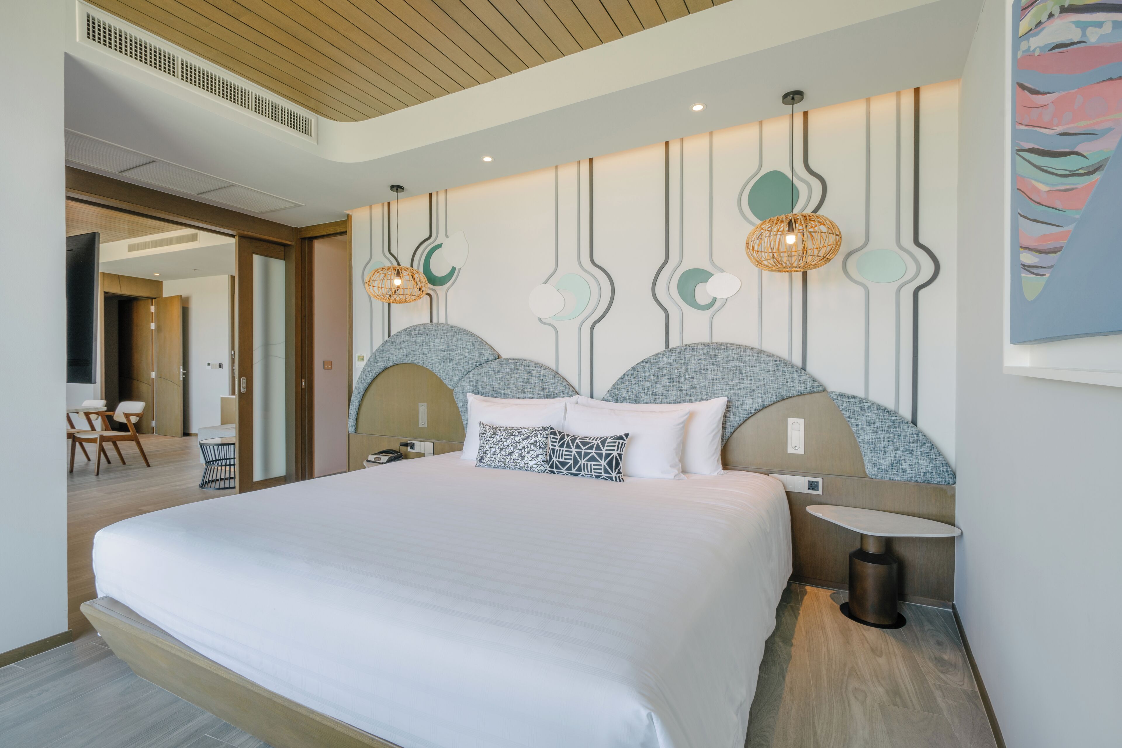 Een moderne hotelkamer met een groot bed, een nachtkastje, een stoel en een wandlamp.