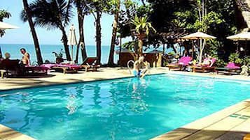 Una piscina techada, una piscina al aire libre, sombrillas