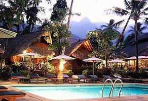 Una piscina techada, una piscina al aire libre, sombrillas