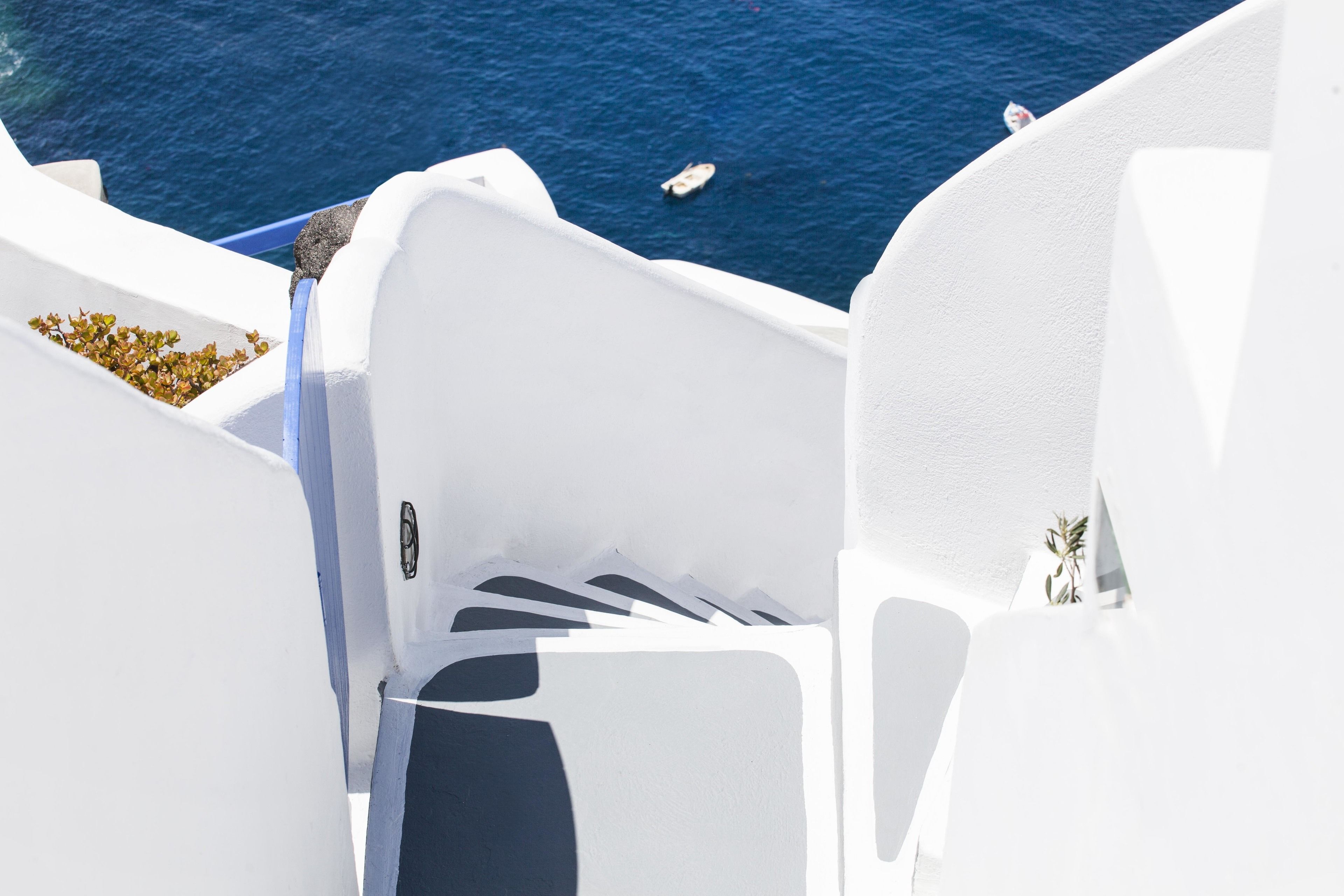 A white architectural structure with a view of the sea.