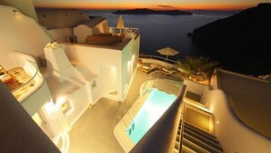 Una piscina en la azotea con vistas al mar al atardecer.