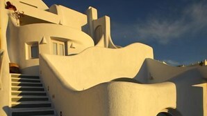 Un edificio blanco con una escalera que conduce a una puerta.