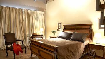 Un dormitorio con una cama de madera, una silla, un escritorio y una lámpara.