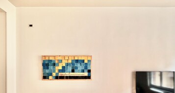 Una pared con un cuadro enmarcado que muestra una cuadrícula de cuadrados azules y amarillos y una cita.