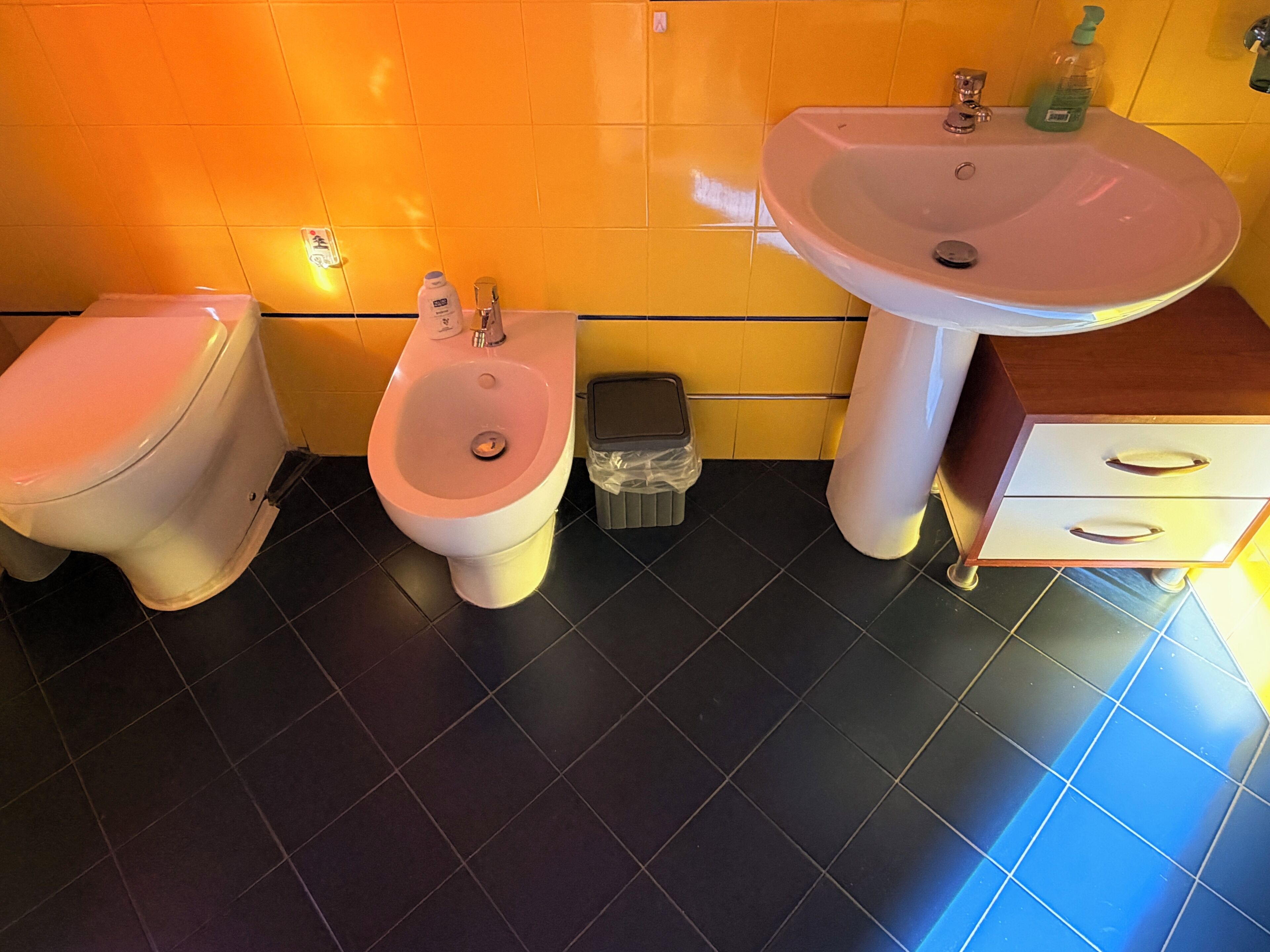 Un baño con inodoro, bidé y lavamanos.