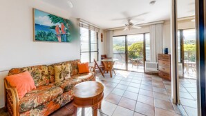 A spacious living area with a sofa, a round table, and a ceiling fan. - Kihei Akahi (Kihei)