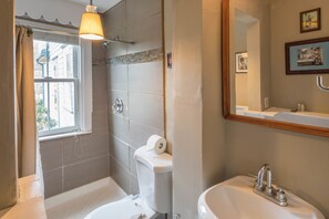 A bathroom with a toilet, sink, and shower.