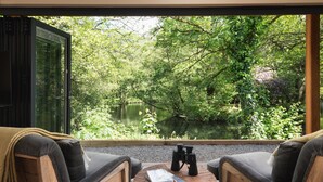 A cozy outdoor seating area with a view of a lake surrounded by lush greenery. - The Turtley Corn Mill (South Brent)
