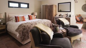 A bedroom with a bed, a wardrobe, a desk with a chair, and a sofa. - The Turtley Corn Mill (South Brent)