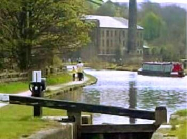 Un canal avec un pont, un bâtiment à la façade blanche et un bateau.