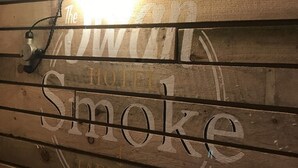 A wooden wall with the text "The Smoke Hotel" and "Taphouse" indicating a hotel and bar area. - The Swan Hotel Smoke & Taphouse (Telford)