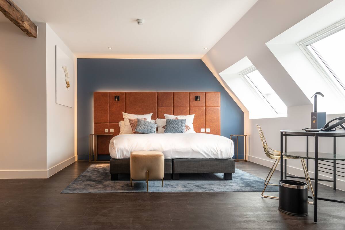 Ein modernes Schlafzimmer mit einem großen Bett, einem Holzkopfstück und einem Oberlicht.